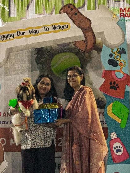 The awards ceremony is a special moment where I get to celebrate the winners. Here, a beautifully dressed Shih Tzu and her parent receive their prize at our Pawsome Olympics photo booth.