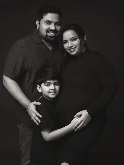 A family portrait, frozen in time. Choosing a black and white palette strips away all distractions, leaving only the pure emotion and connection between a family on the verge of welcoming a new member. This is a true family heirloom.