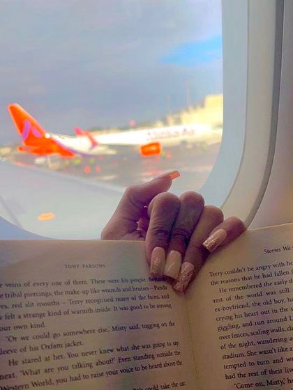 Stay on point with high-quality, beautiful nails, even when you're flying. This picture captures my client's stylish nails while reading on a plane.