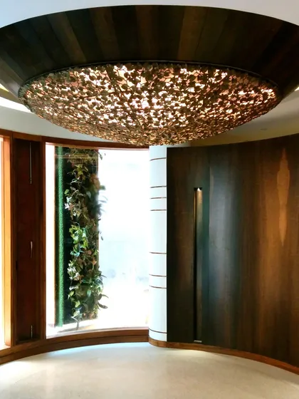 A view of the curved interior space in the Outré House, showing the unique ceiling light fixture and the seamless flow between different areas of the home.