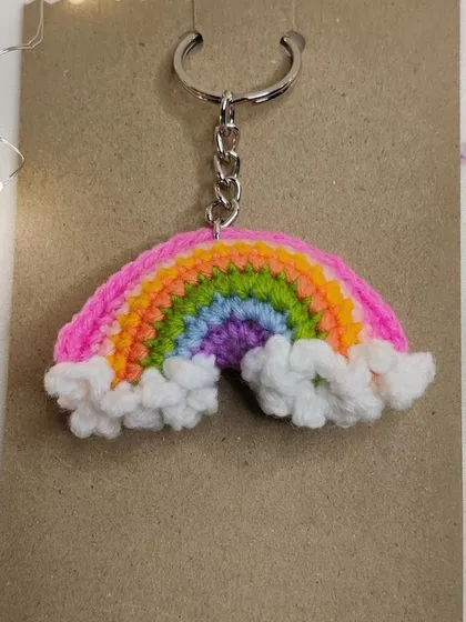 A vibrant rainbow keychain with fluffy white clouds, because who doesn't love carrying a rainbow around?