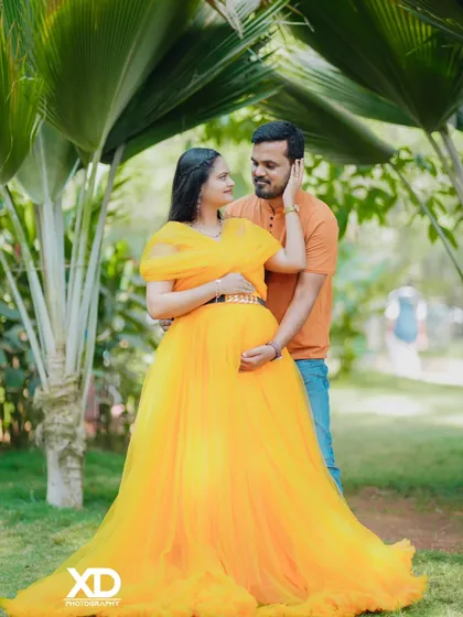 A tender moment captured in a sun-drenched garden. This photo showcases a beautiful yellow gown and the loving connection between the couple in a natural, romantic setting.