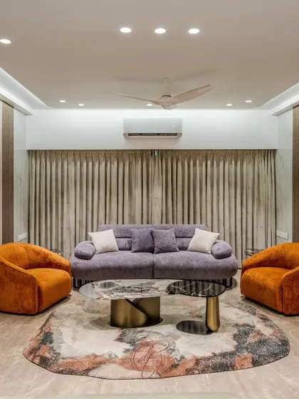 A symmetrical view of the living room, showing how the arrangement of the sofa and armchairs creates a perfect space for conversation. The cove lighting adds a soft, ambient glow to the entire room.