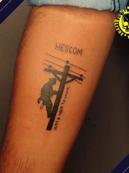 A very unique tattoo dedicated to a lineman's profession at HESCOM. It shows a silhouette of a worker climbing an electric pole with the text "Just a walk to work."