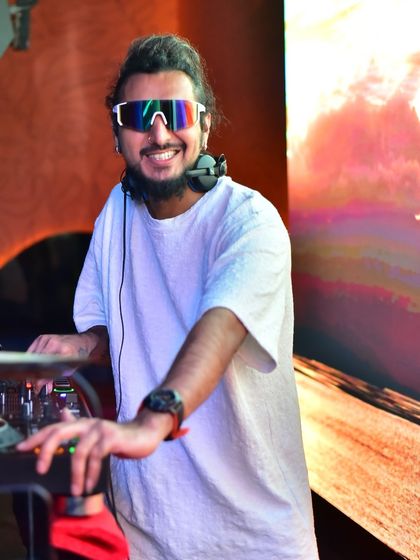 A happy moment behind the decks, with the bright, warm colors of the video wall creating a great atmosphere.