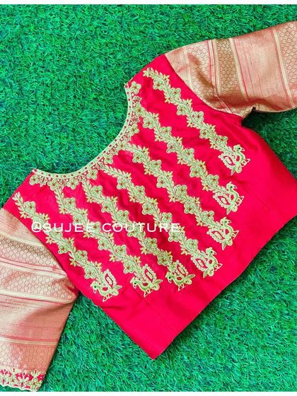 A vibrant red blouse with contrasting gold brocade sleeves. The body of the blouse features vertical lines of gold zardozi embroidery, creating a unique pattern.