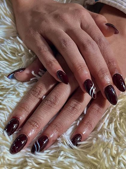 Bold, beautiful, and ready to shine. This design features a deep maroon polish with a simple, clean white line art accent for a touch of modern flair.