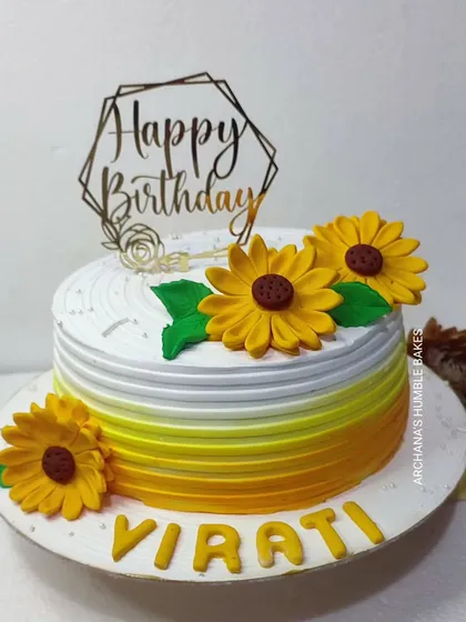 A cheerful cake with fondant sunflowers and a yellow ombre design.