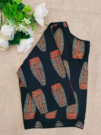 A black cotton boatneck blouse with a leaf-inspired block print.