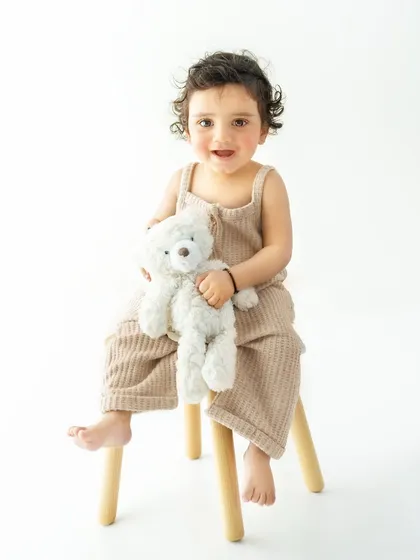 A full body shot showing the adorable combination of the neutral toned outfit and the simple wooden stool. This is a perfect example of my minimalist and timeless approach to baby portraits.