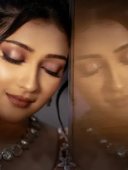 An artistic bridal portrait using a reflection. This creative shot adds depth and a dreamy quality, highlighting her serene expression.