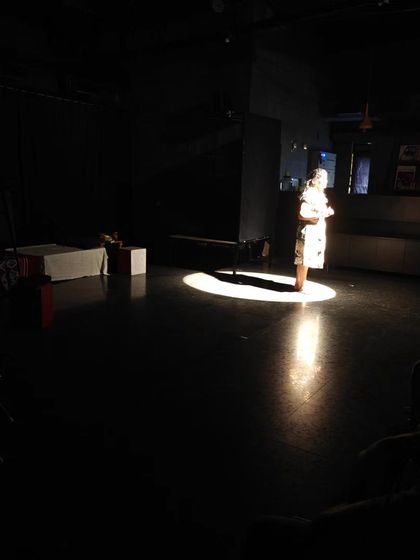 A single actor holds the stage, captured in a tight spotlight. This powerful image represents the focus on individual growth and confidence-building in our acting course.