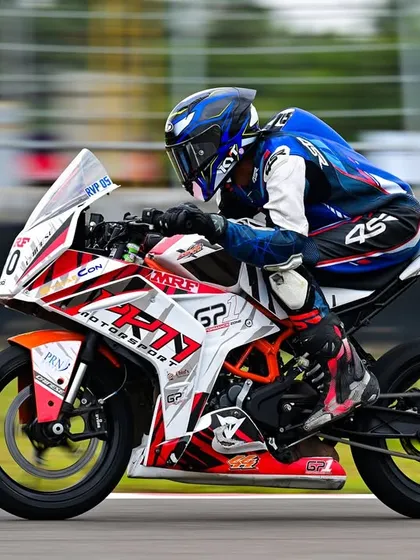 A side view of Rohith in action, showcasing the PRN Motorsport livery on his KTM race bike.