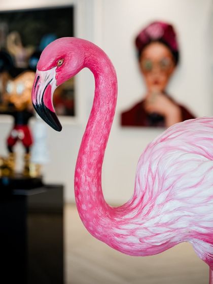 A close-up of the flamingo sculpture's head and neck, showing the detailed texture of its feathers and its elegant form.