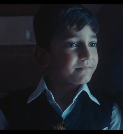 A close-up of one of the young actors. His classic school uniform with a white shirt and vest helps build a nostalgic and innocent character.