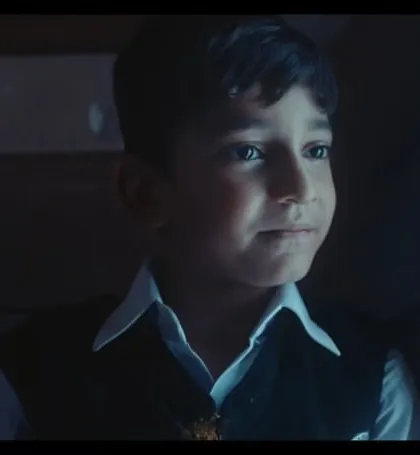 A close-up of one of the young actors. His classic school uniform with a white shirt and vest helps build a nostalgic and innocent character.