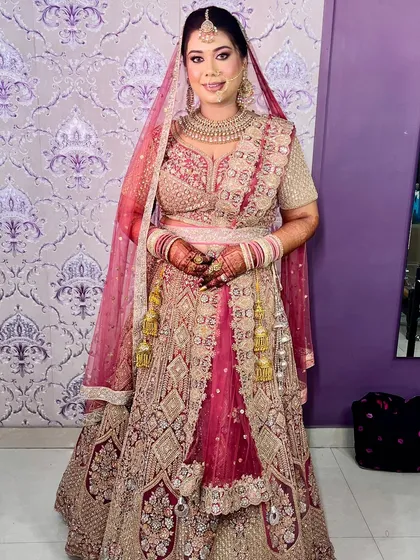 The full bridal look. This bride is slaying in a gorgeous pink and gold lehenga, with makeup that enhances her natural beauty and radiance.