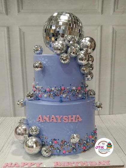 A dazzling disco-themed cake that's ready to party. This two-tiered lavender cake is covered in sparkling disco balls, perfect for a groovy celebration.