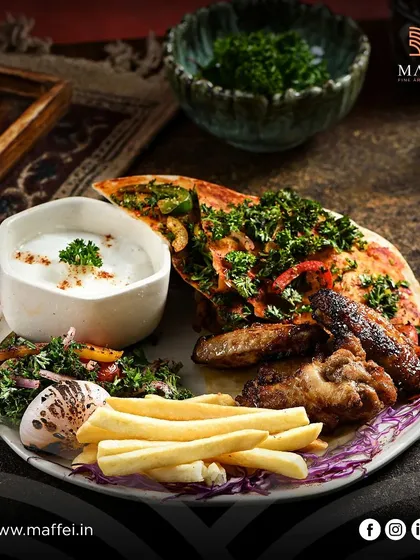 A generous platter of our grilled specialties, including juicy Shish Tawook and Jawaneh Meshwi (chicken wings), served with fries and a side of creamy garlic dip.