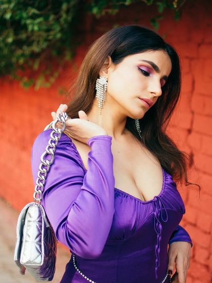 A vibrant portrait against a bright red wall, showing how I use color to create bold and eye-catching images. The purple dress and silver bag pop against the background, making for a striking fashion shot.