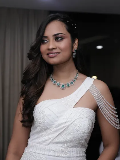 A three-quarter view that captures the subtle elegance of this nude makeup look. The hair is styled with delicate pearl pins for a touch of glamour.