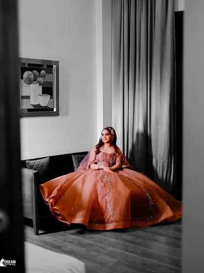 A unique portrait of Tanya seated on a sofa, the black and white edit with a pop of color on her gown creating a dramatic effect.