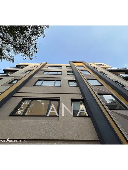 A worm's-eye view of the Yellow Line Apartment building, capturing the full height and the dynamic composition of lines and colors that define its modern architectural identity.