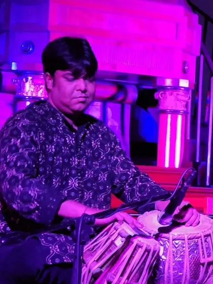 Performing in a contemporary setting with vibrant stage lighting. This image captures the focused energy I bring to my fusion performances, where I adapt the tabla to genres like rock, jazz, and Sufi music.