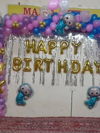 A simple and effective birthday backdrop for a home party. This setup uses a foil curtain, "Happy Birthday" foil letters, and a balloon arch with character accents.