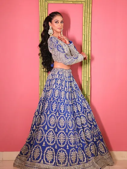 A side profile showcasing the modern ponytail hairstyle and the detailed work on the blouse.