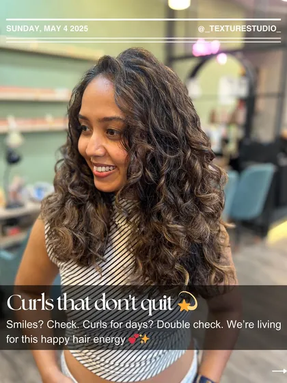 Curls that don't quit. This happy client is all smiles, showing off her long-lasting, defined curls after a styling session at the studio.