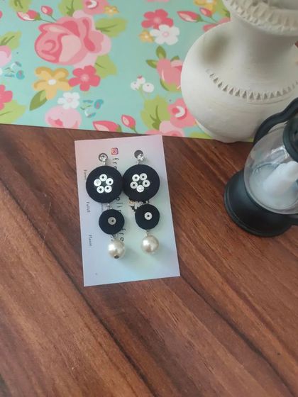These tiered fabric earrings with pearl drops are a modern and chic design. They are available in pink, black, and teal, and are incredibly lightweight and comfortable.