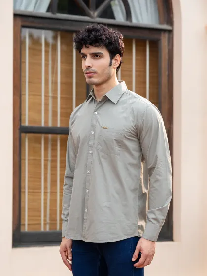 A classic lookbook-style shot for an MG Motor men's shirt. The clean composition and neutral background keep the focus entirely on the product's fit and design.