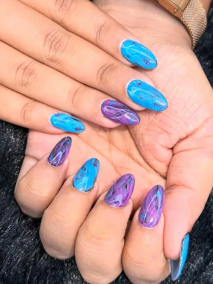 A vibrant and artistic marble design. This set features a bold mix of blue and purple, creating a mesmerizing, fluid pattern on each nail.