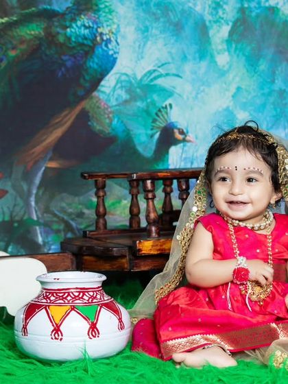 Another adorable shot of little Radha, looking joyful in her colorful outfit.