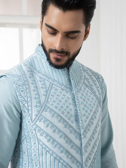 A close up of a powder blue embroidered vest. The intricate, geometric threadwork demonstrates a modern approach to traditional Indian craftsmanship.