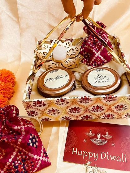 Holding up the basket-style Diwali gift set, showcasing its design and contents.