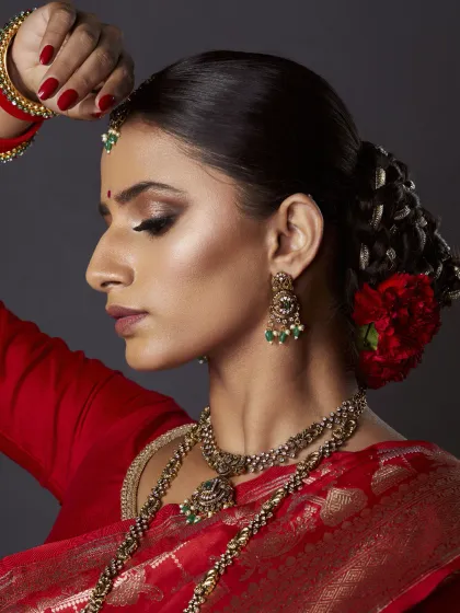 A closer look at my signature bridal style. I created a sharp, smokey eye and paired it with a flawless, glowing base. The traditional bridal bun is adorned with fresh red carnations for a classic royal touch.