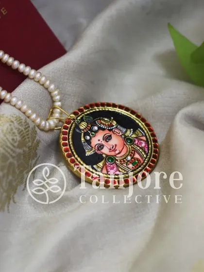 This completely handmade Tanjore pendant features Krishna, allowing you to wear your beloved deity close to your heart.