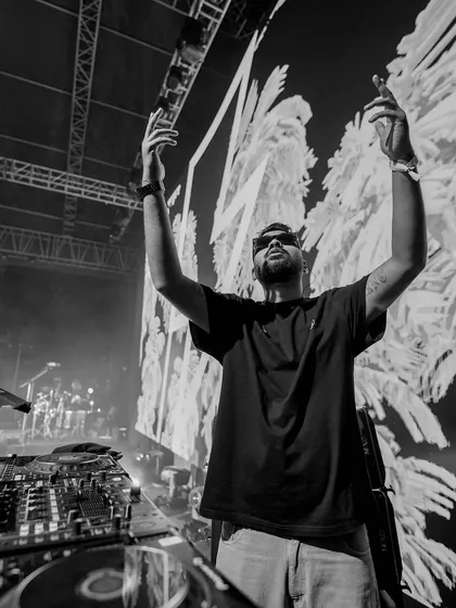 Hands up to the sky on stage. A black and white shot capturing a moment of connection with the music and the crowd.