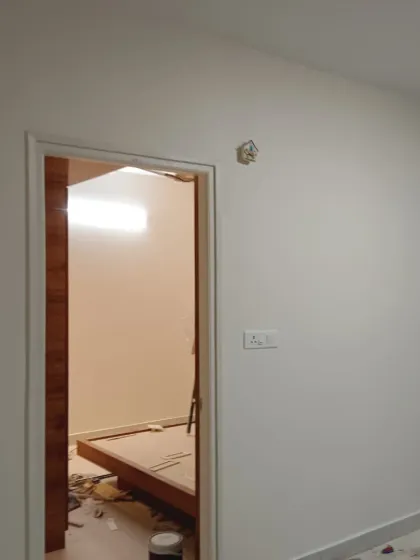 A project in progress, showing a wooden door frame ready for its final finish, set against newly painted walls.