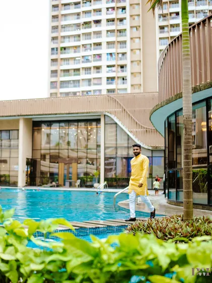 The groom walking by the poolside in his Haldi attire, a modern and stylish take on a traditional pre-wedding event.