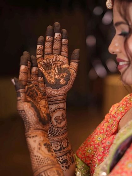 A close-up of a bride's hands, showing the intricate details of her bridal mehandi.