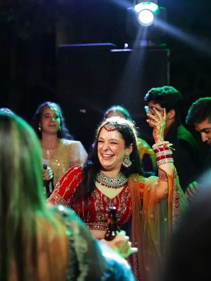 Her armor is her bridal look. The bride dancing with a drink in her hand, enjoying her sangeet night to the fullest.