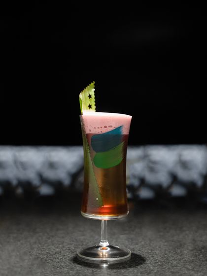The 'Coorg Highball' is a vibrant mix of Scotch, coffee, banana, citric acid, and an Asian fresca. The colorful layers make it as visually appealing as it is delicious.