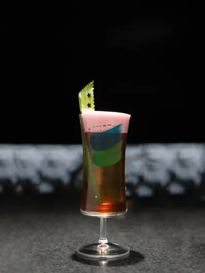 The 'Coorg Highball' is a vibrant mix of Scotch, coffee, banana, citric acid, and an Asian fresca. The colorful layers make it as visually appealing as it is delicious.