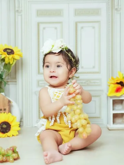 A sunny and cheerful studio setup with sunflowers and grapes. This theme is perfect for a bright and happy baby photoshoot.