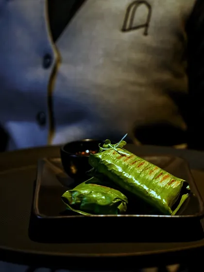 At Lair, our team ensures every guest receives nothing short of perfection. Here, a server presents our pandan-wrapped chicken, a dish full of aromatic flavor.