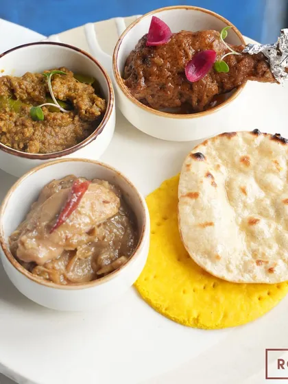 A platter from the "Zaika-e-Rooh" pop-up, featuring Chicken Qorma, Chicken Stew, and Mutton Hari Mirchein Keema, served with traditional Sheermal and Tandoori Roti.