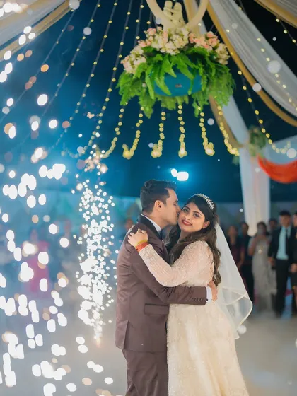 The couple's first dance at their Catholic wedding reception, surrounded by the magical glow of sparklers and string lights.